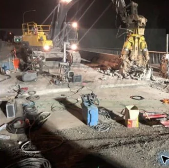 Concrete worksite with specialist equipment and temporary lighting